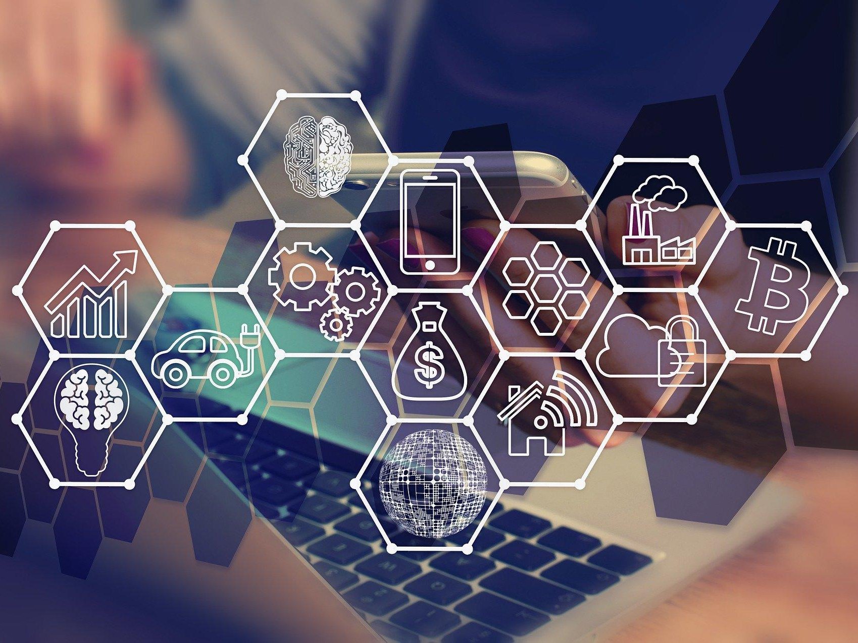 Laptop und Smartphone im Hintergrund, vernetzte Icons im Vordergrund