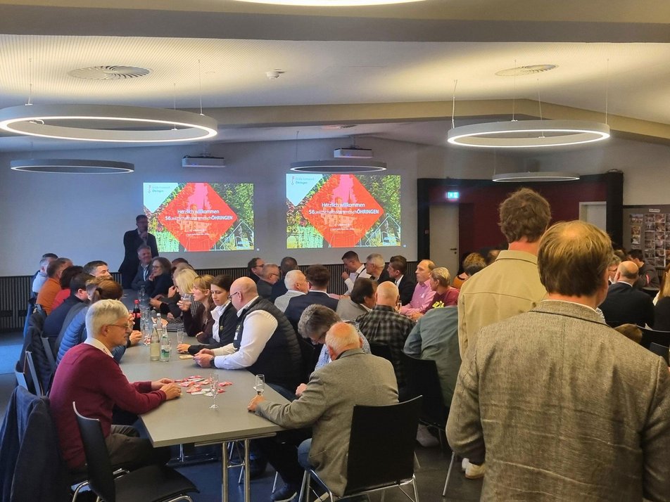 Teilnehmende des Wirtschaftsstammtisches hören Oberbürgermeister Thilo Michler bei Rede zu