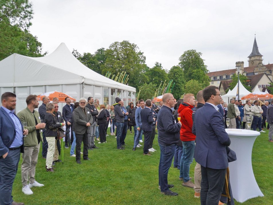 Teilnehmende zur Messeröffnung stehen auf Allmand