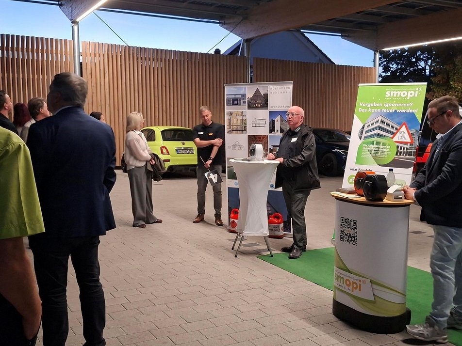 Teilnehmende während des Rundgangs am Stand zu E-Ladestationen und Überdachung mit Photovoltaik Teilnehmende während des Rundgangs am Stand zu E-Ladestationen und Überdachung mit Photovoltaik