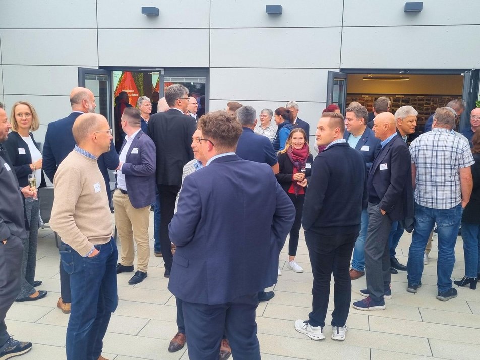 Teilnehmende des Wirtschaftsstammtisches netzwerken auf der Dachterrasse
