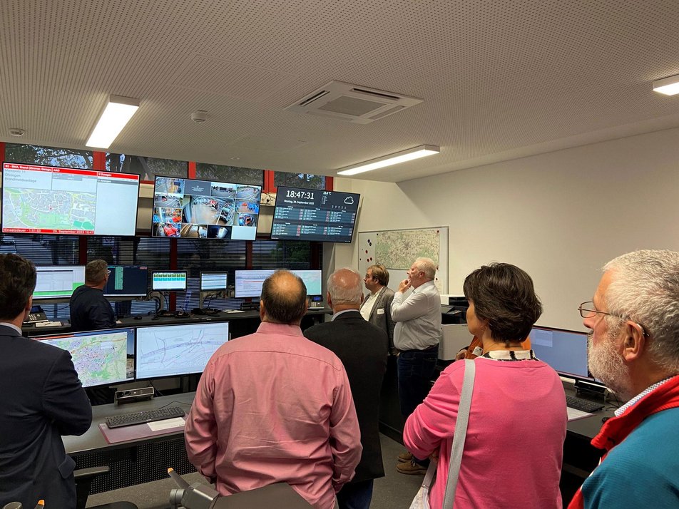 Teilnehmende des Wirtschaftsstammtisches stehen in Einsatzzentrale